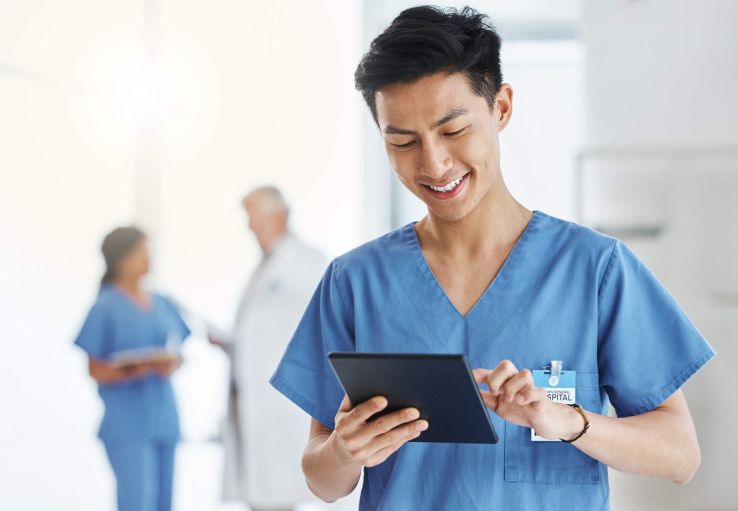 Ein Pfleger tippt Daten in ein Tablet