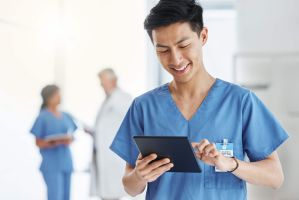 Ein Pfleger tippt Daten in ein Tablet