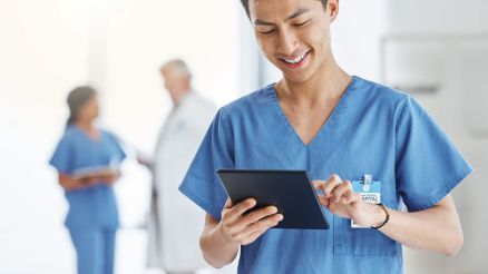 Ein Pfleger tippt Daten in ein Tablet