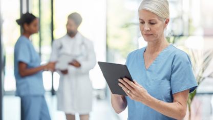 Eine Pflegerin arbeitet mit einem Tablet